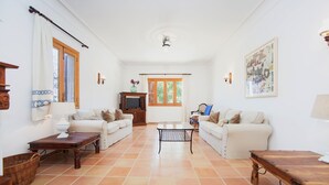 A spacious living room with two white sofas, a wooden coffee table, and a television. - SA CORBAIA NOVA  - Villa with private pool in Arta. Free WiFi (Artà)