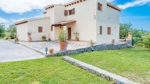 A two-story house with a tiled patio and potted plants. - CAN CANALS - Villa with private pool in Artà. Free WiFi. (Artà)
