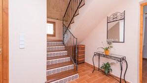 A staircase with patterned tiles, a metal console table with a plant, and a wall-mounted mirror. - CAN CANALS - Villa with private pool in Artà. Free WiFi. (Artà)