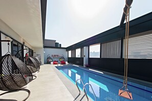 Una piscina al aire libre, tumbonas