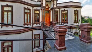 Un edificio de varios pisos con una entrada central, una escalera y un balcón.