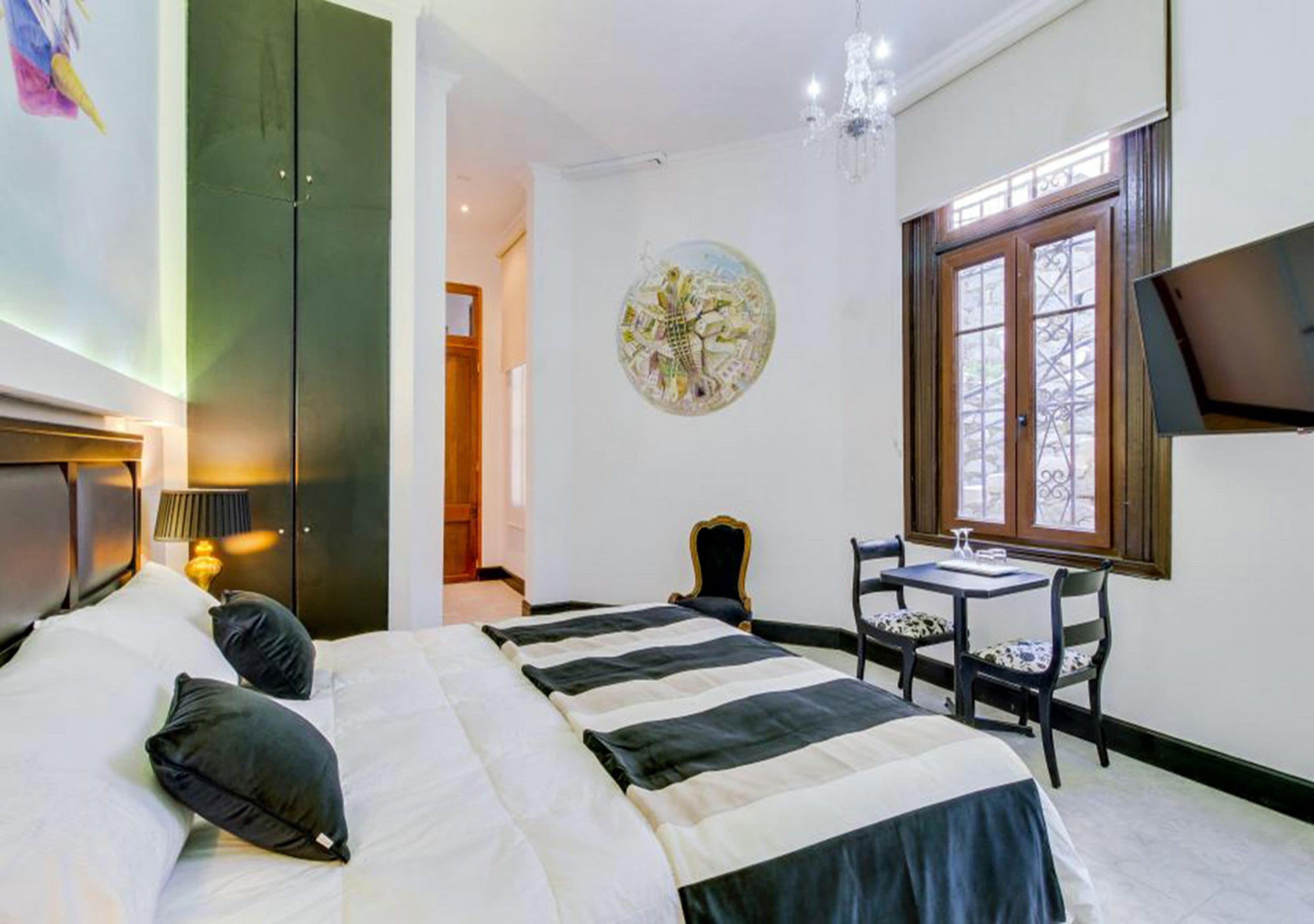 Habitación de hotel con una cama grande, un escritorio y un televisor.