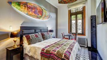 Un dormitorio con cama, mesitas de noche, ventana y radiador.