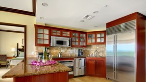 A modern kitchen with granite countertops, stainless steel appliances, and wooden cabinetry.