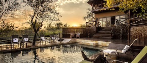 Una piscina al aire libre, tumbonas