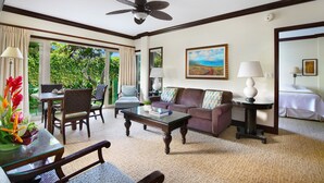 A hotel room with a large window, a ceiling fan, a sofa, a coffee table, and a bed. - Waipouli Beach Resort Luxury Garden Ground Floor! AC Pool (Kapaa)