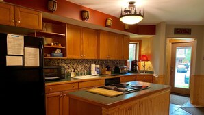 A kitchen with wooden cabinets, a refrigerator, a microwave, a sink, and a stove. - Townhome G5 - 4th Lake (Inlet)
