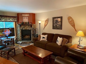 A cozy living room with a fireplace, a television, and a comfortable seating area.