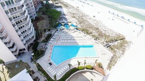 A resort with a large pool, beach access, and a multi-story building with balconies.