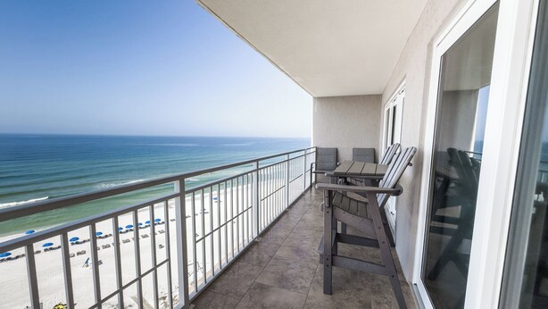 A balcony with a view of the beach and ocean.