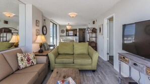 A living room with a sofa, coffee table, and TV stand.