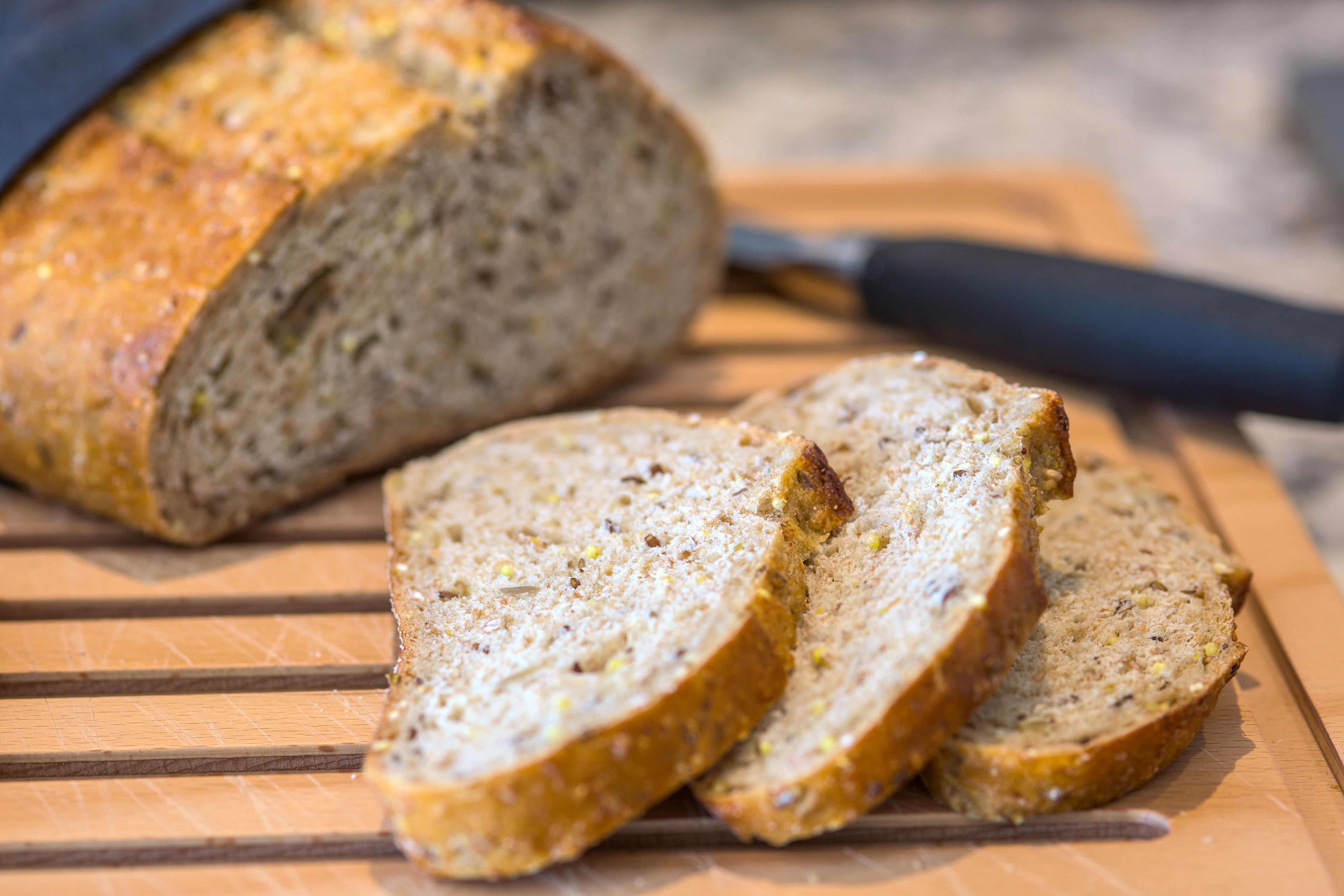 A loaf of sliced bread on a wooden cutting board.