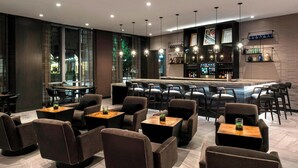 A modern bar area with seating and a bar counter. - AC Hotel by Marriott Boston Cleveland Circle (Boston)