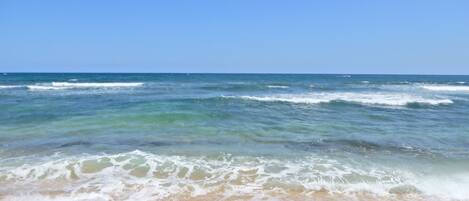 A beach with waves approaching the shore.