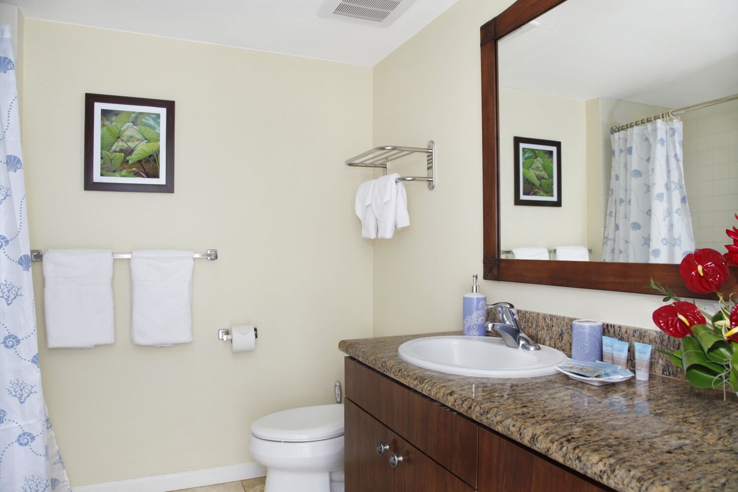 Une salle de bain équipée d’un lavabo, d’un miroir, de toilettes et d’un porte-serviettes.