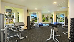 A gym with treadmills, weight machines, and exercise balls.