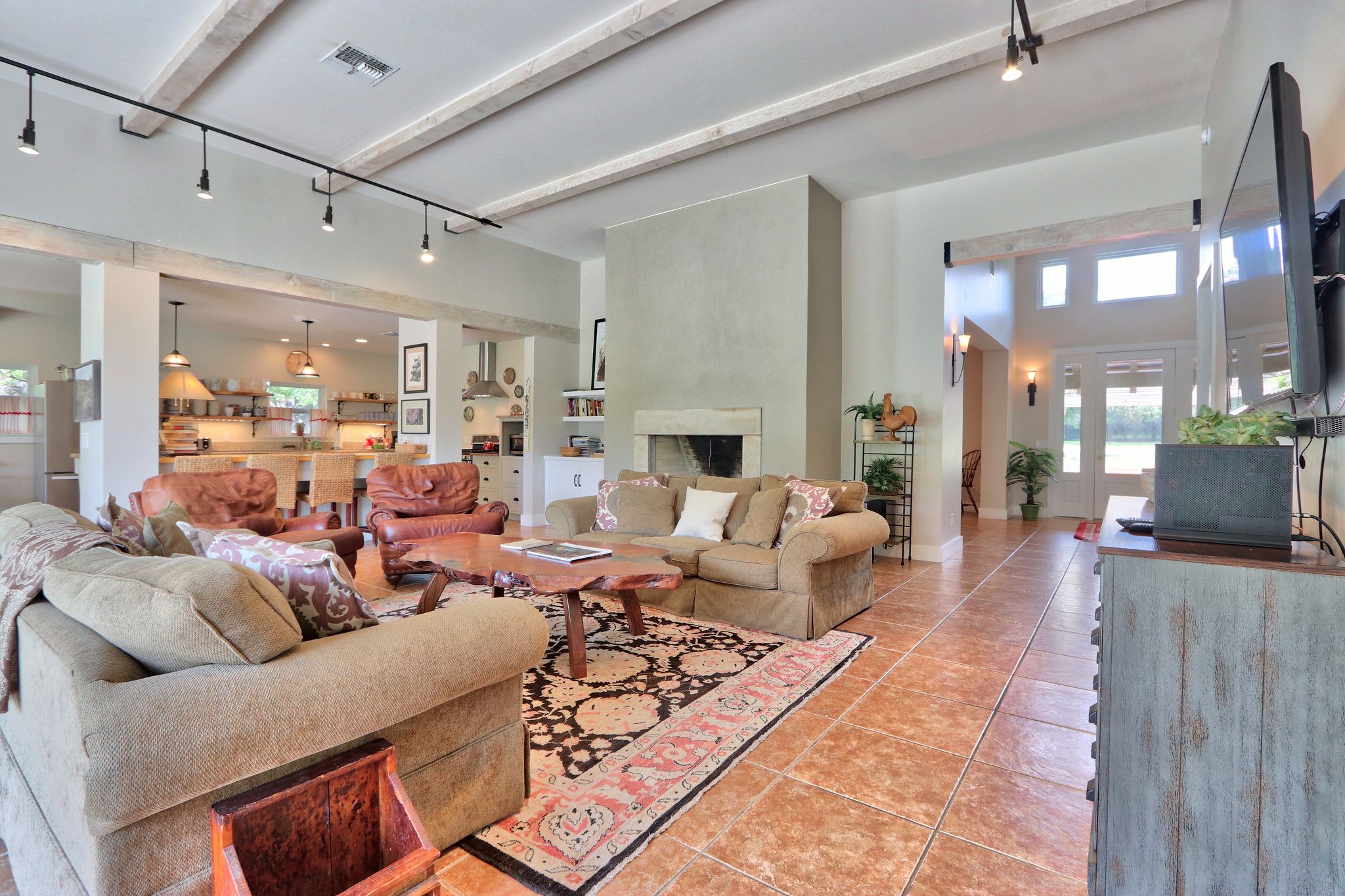 A spacious living area with a fireplace, sofas, and a television.