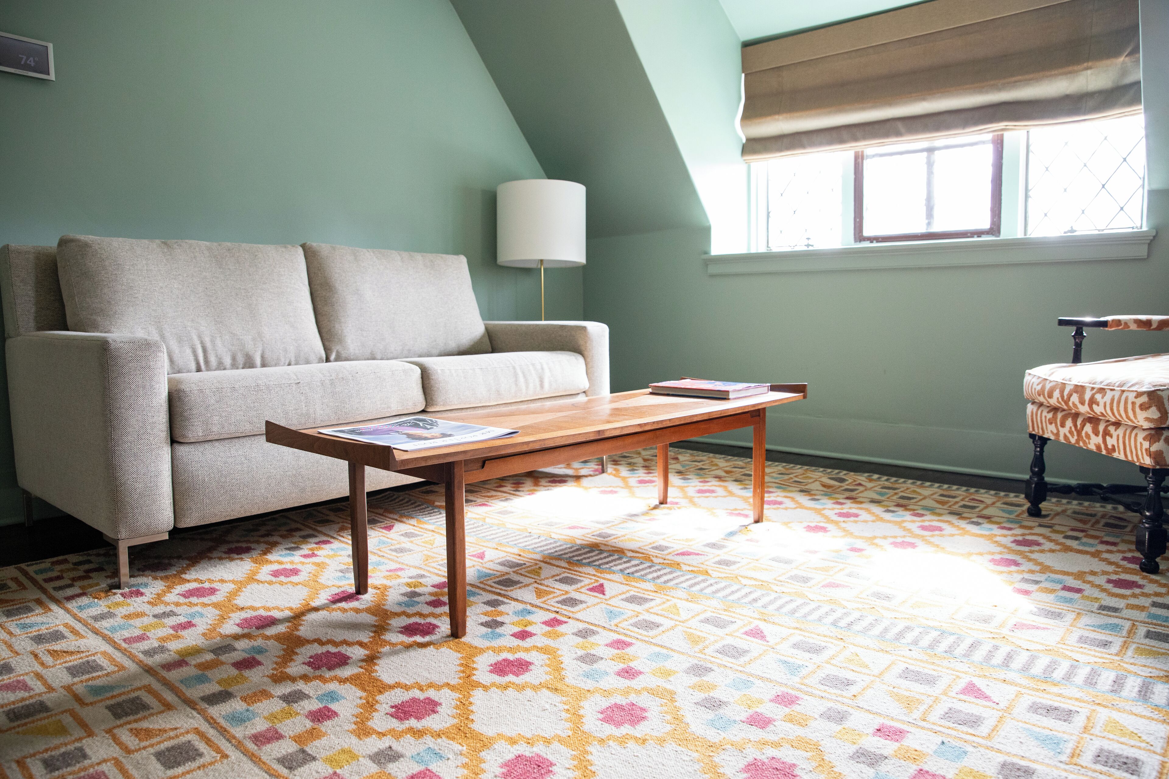 A living room with a sofa, a wooden coffee table, and a patterned rug.