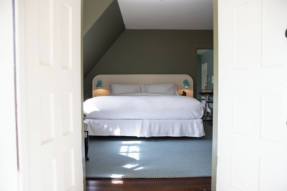 Une chambre à coucher avec un lit, des lampes de chevet et une vue sur la salle de bain.