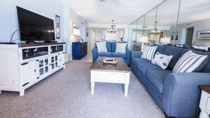 A living room with a TV, sofa, coffee table, and cabinets. - E805 Great Gulf View, 3 pools, Gym & Tennis Court (Panama City)