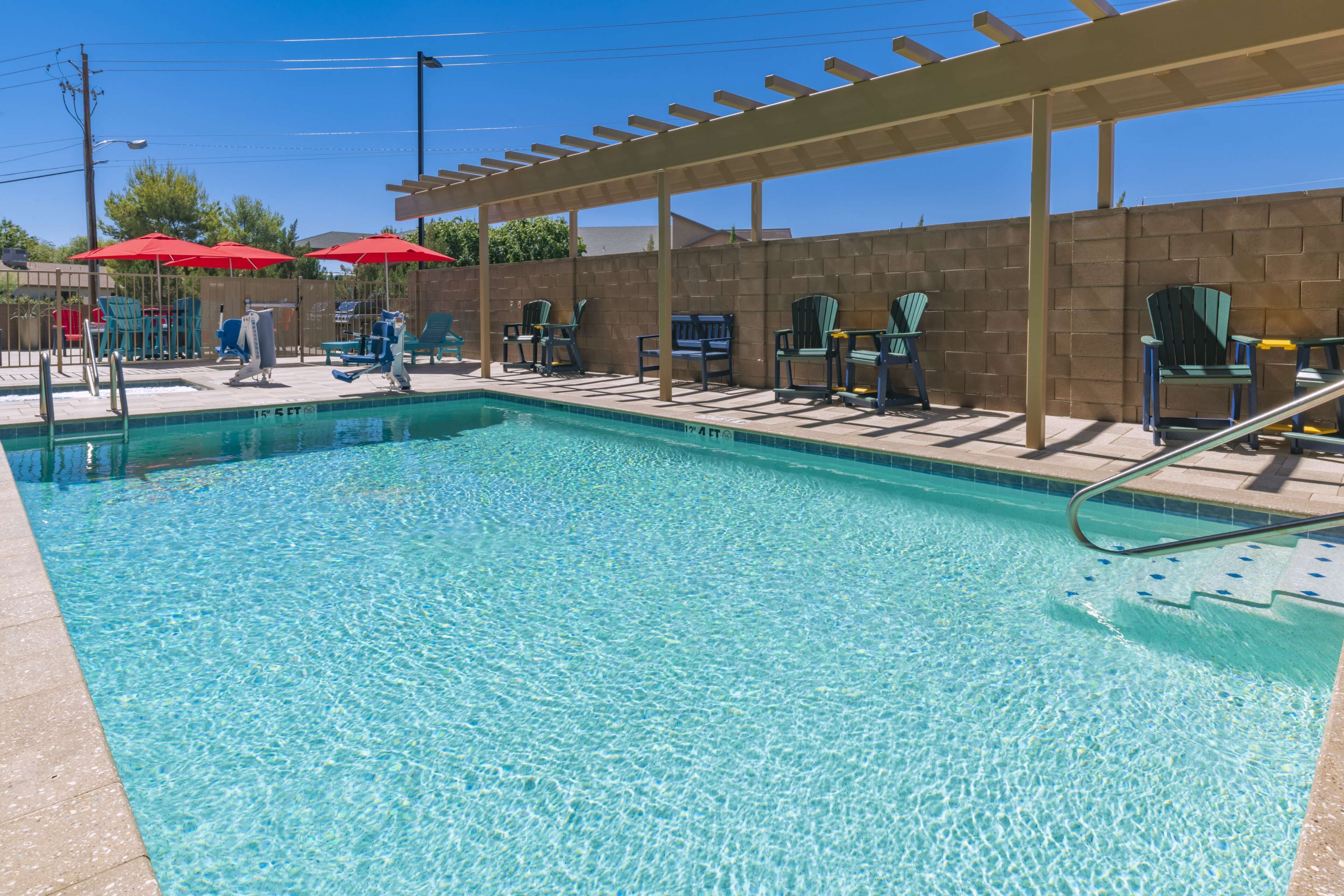 A clear swimming pool with lounge chairs and umbrellas.