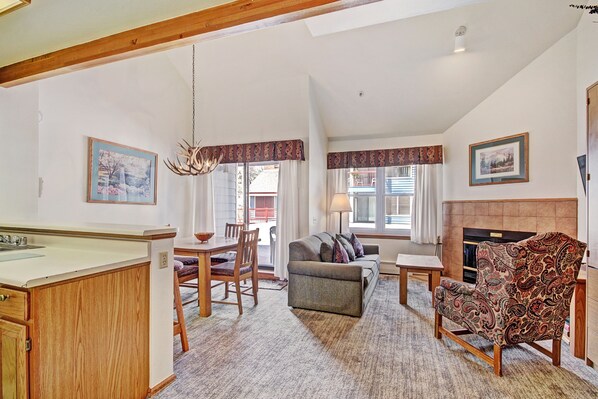 Cozy living area with a fireplace, dining table, and comfortable sofa.