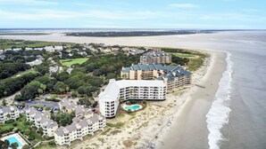 An aerial view of a coastal hotel with multiple buildings, a beach, and a golf course. - 513 Seascape by AvantStay Oceanfront Home w/ Amazing View & Community Pool (Isle of Palms)