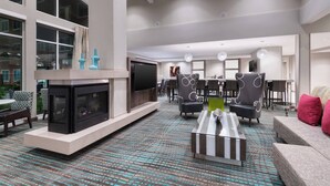 A spacious living area with a fireplace, comfortable seating, and a large TV. - Residence Inn by Marriott Spartanburg Westgate (Spartanburg)