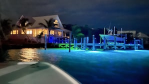 A waterfront property with a house, dock, and swimming pool. - Hope Town harbor period home with lighthouse view (Hope Town)