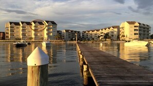 A waterfront hotel with multiple buildings, a wooden pier, and boats in the water. - Amazing View from this Contemporary, Upscale Condo, Parking, Pool - Baywatch E10 (Pensacola Beach)