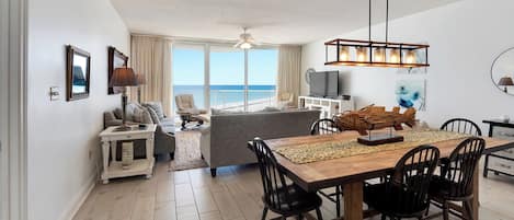 A spacious living area with a dining table, chairs, a sofa, and a TV.