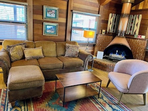 A cozy living room with a sectional sofa, a small table, and a fireplace.
