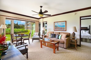Relax in a spacious room with a sofa, armchairs, and a coffee table, offering a view of the surrounding landscape.