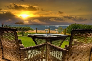 Enjoy a tranquil ocean view from this serene outdoor setting, complete with a table for two and a pathway to the beach.