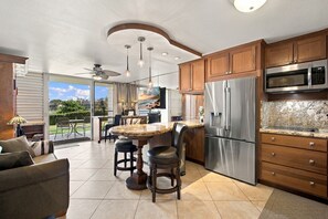 A modern kitchen with a central island, stainless steel appliances, and a view to the outdoors.