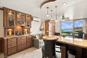 A kitchen with a large island, wooden cabinets, and a view of the ocean.