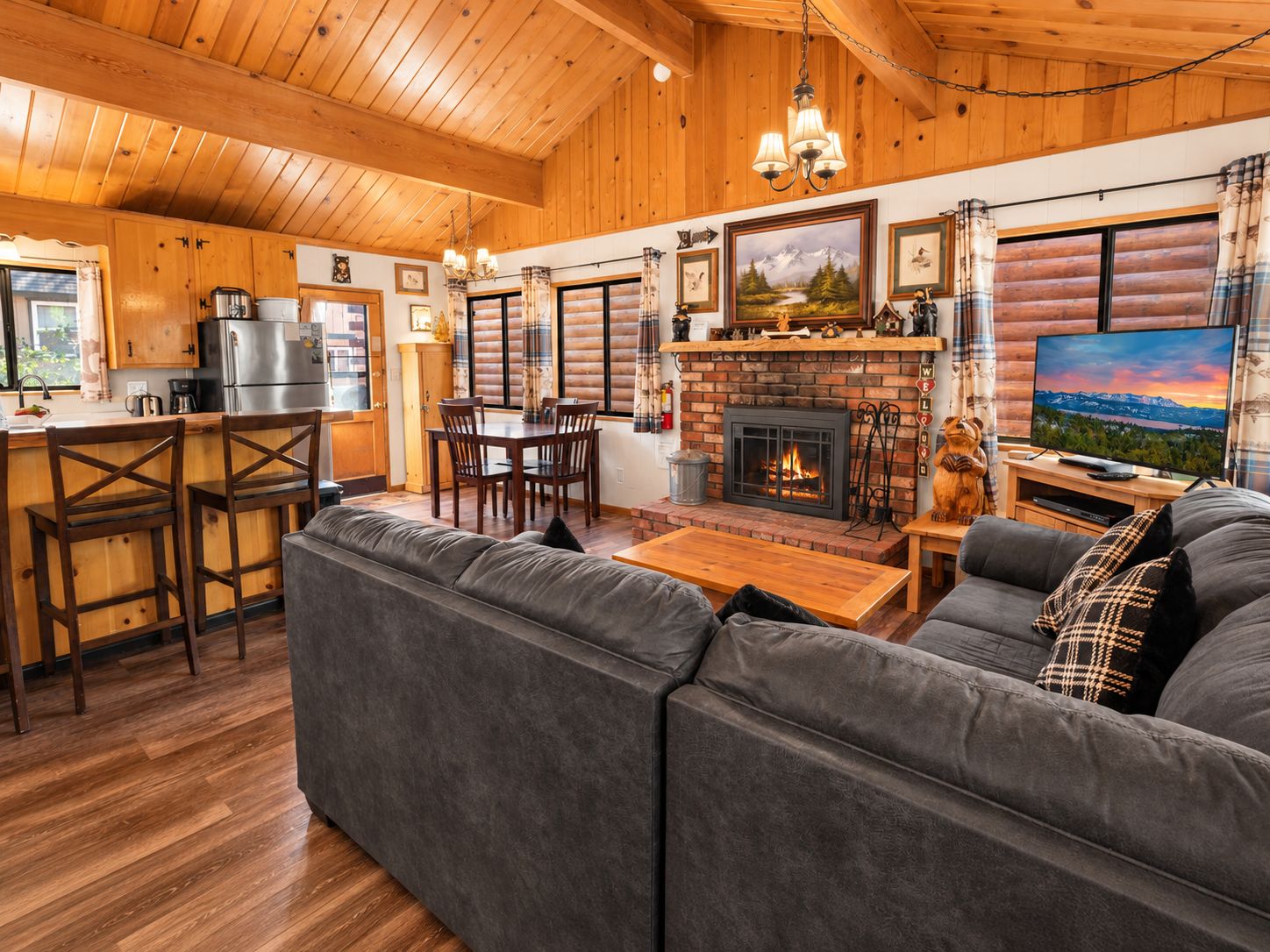Un interior de cabaña acogedor con chimenea, muebles de madera y televisor.