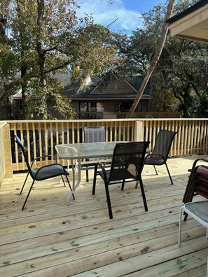 A wooden deck with a glass table and four chairs. - Perfect couples retreat close to Shipyard Beach  Club 193 Beachwalk (HIlton Head Island)