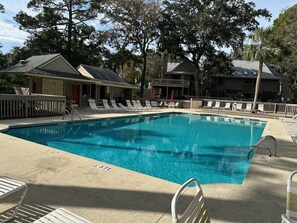 A rectangular swimming pool with a 5ft depth marker, surrounded by lounge chairs and a wooden deck. - Perfect couples retreat close to Shipyard Beach  Club 193 Beachwalk (HIlton Head Island)
