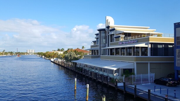 A waterfront building with a restaurant named "Blue Moon Fish Co." on the second floor. - Newly Remodeled Home - Steps away from white sand beaches!!! (Lauderdale-By-The-Sea)