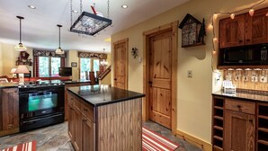 A spacious kitchen with a central island, wooden cabinetry, and a built-in microwave.