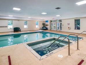 A swimming pool with a no diving sign, a bench, and a chair.