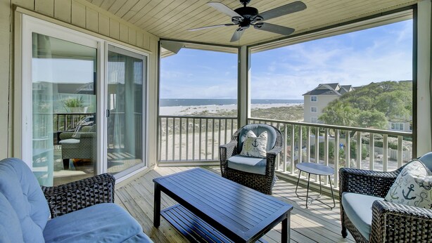 A covered balcony with wicker furniture, a ceiling fan, and a view of the beach. - 304 E Port by AvantStay | Rooftop Deck | Incredible Ocean & Beach Views! (Isle Of Palms)