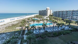 Een resort met zwembad, strand en uitzicht op de oceaan.