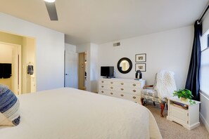 A bedroom with a large bed, a dresser, a television, a chair, and a window with curtains. - < 8 Mi to Old Town: Condo w/ Community Perks! (Scottsdale)