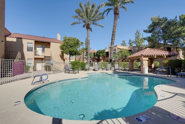 A swimming pool with lounge chairs, palm trees, and a poolside area with a fence. - < 8 Mi to Old Town: Condo w/ Community Perks! (Scottsdale)