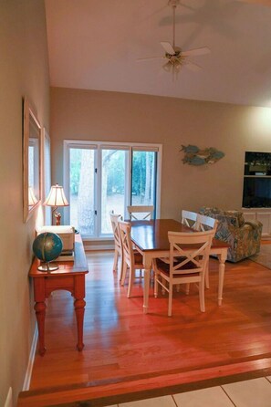 Zona pranzo con tavolo e sedie in legno, un mappamondo su un tavolino e una ventola a soffitto.