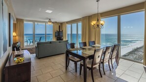 Une chambre d’hôtel avec un balcon, un coin repas, un canapé et une télévision.