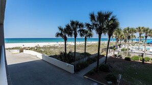 A beachfront property with a view of the ocean, palm trees, and a pool area. - C106 Low Floor, Stunning sunset, Pool View, covered parking space (Panama City Beach)