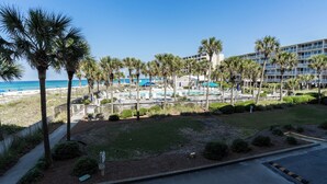 A resort with a pool area, palm trees, and a beach view. - C106 Low Floor, Stunning sunset, Pool View, covered parking space (Panama City Beach)